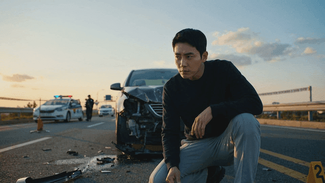 A man examining a car accident scene on a highway
