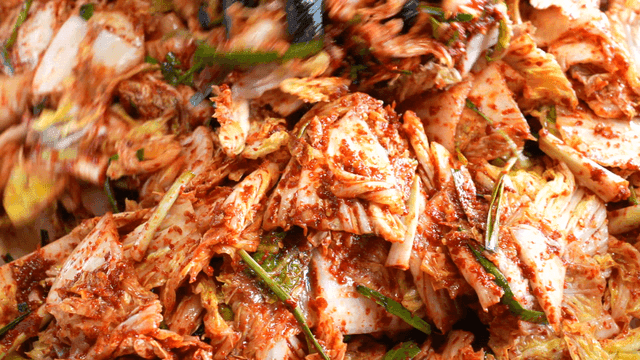 Kimchi being mixed with spices