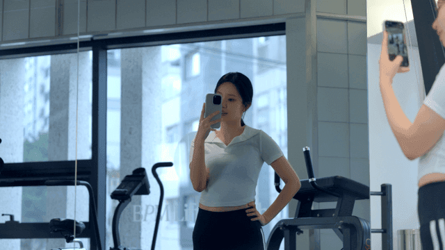 헬스장에서 거울을 보며 셀카를 찍는 젊은 여성