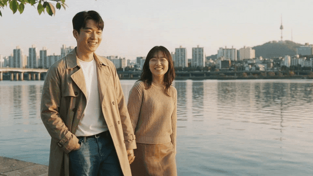 Couple walking along city riverside