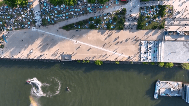 People enjoying a riverside park with jet skis