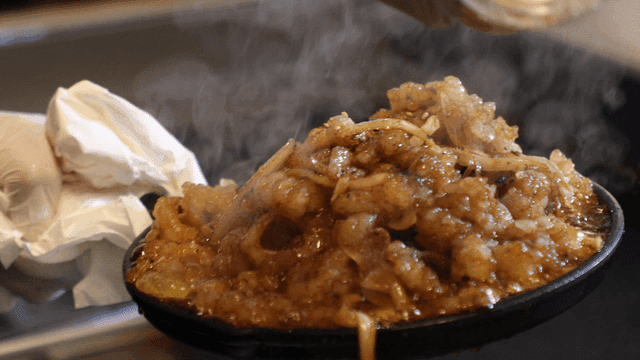 Sesame seeds sprinkled on sizzling stir-fried large intestine