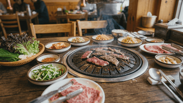Beef on grill plate accompanied by various side dishes