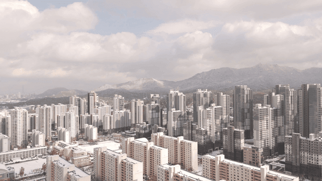Snow-covered cityscape with mountains