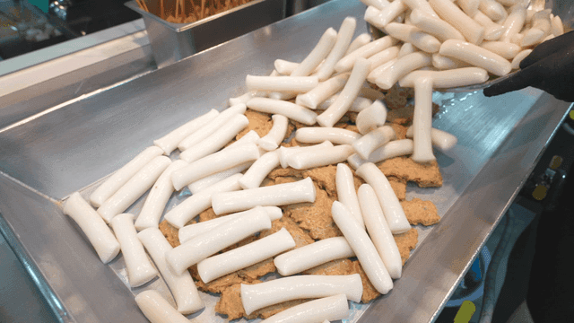 Rice cakes being placed on fish cakes