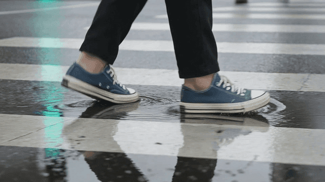 Shoes walking on wet crosswalk after rain