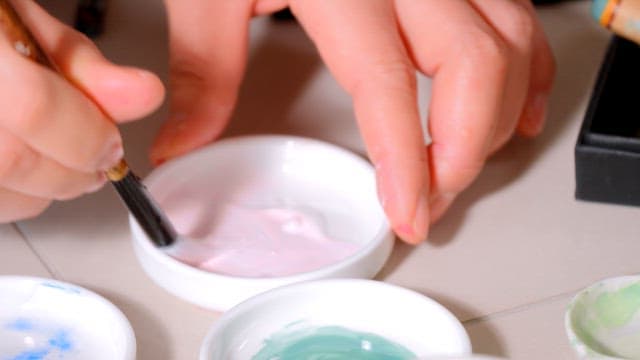 붓으로 물감을 섞는 화가의 손