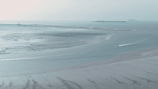 Calm sea with boat in distance.