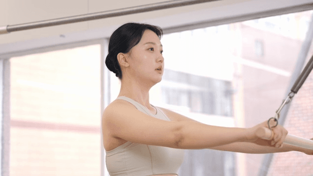 Pilates instructor guiding a student indoors