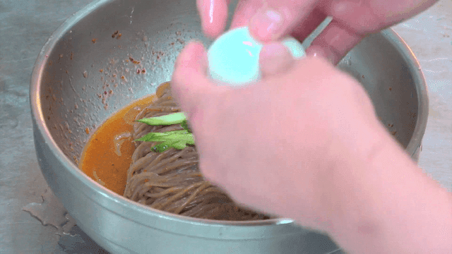 Bibim naengmyeon topped with egg and cucumber