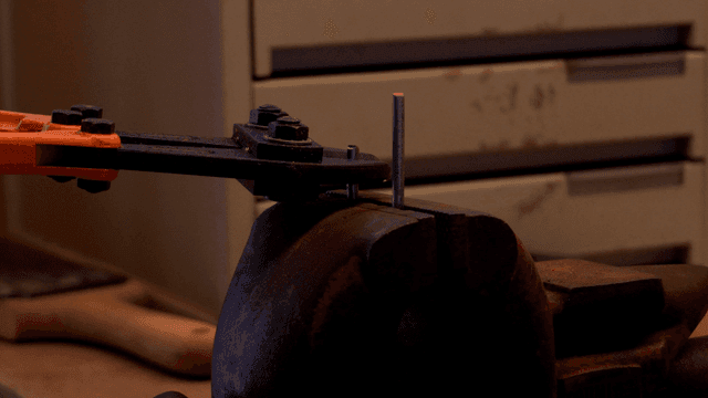 볼트 커터로 금속 막대 자르는 모습