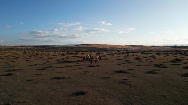 People riding camels in a vast desert