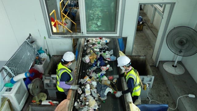 Workers sorting garbage at a recycling facility