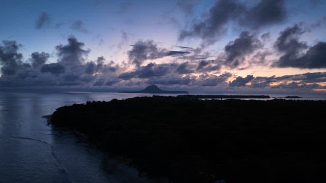 Island at dawn with clouds and ocean