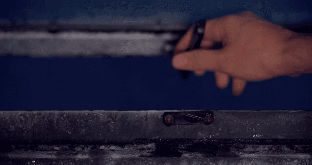 서리가 낀 창문의 걸쇠를 열고 닫는 손