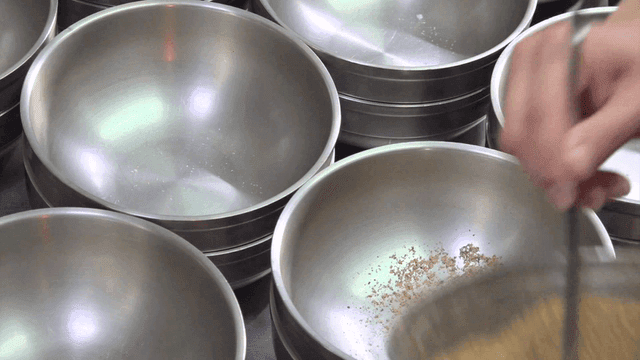 Pouring soybean powder over bowls with measuring spoon