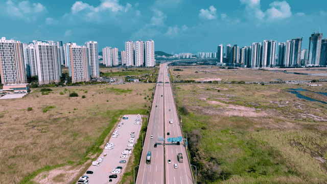 Highway leading to city with high-rise buildings