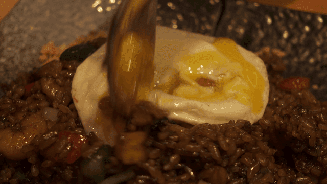 Spoon mixing Jajang fried rice topped with fried egg
