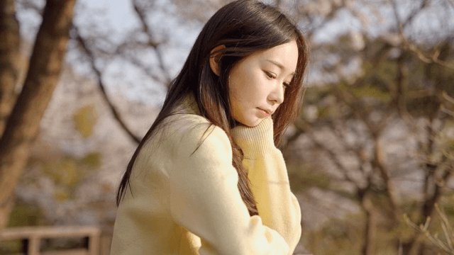 공원 난간에 기대어 생각에 잠긴 여성