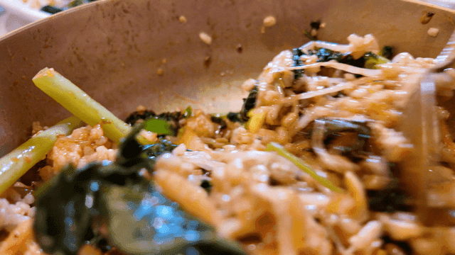 Bibimbap being mixed in a bowl
