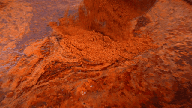 Red pepper powder poured into large pot