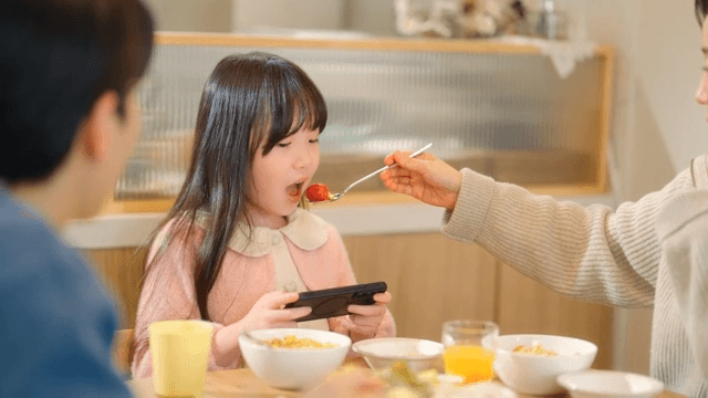 식탁에서 핸드폰에만 집중하는 아이