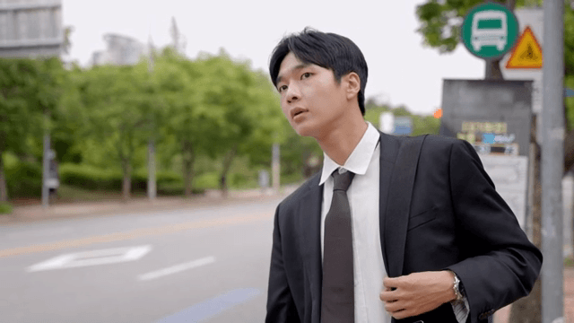 정류장에서 버스를 기다리다가 택시를 잡는 직장인 남성