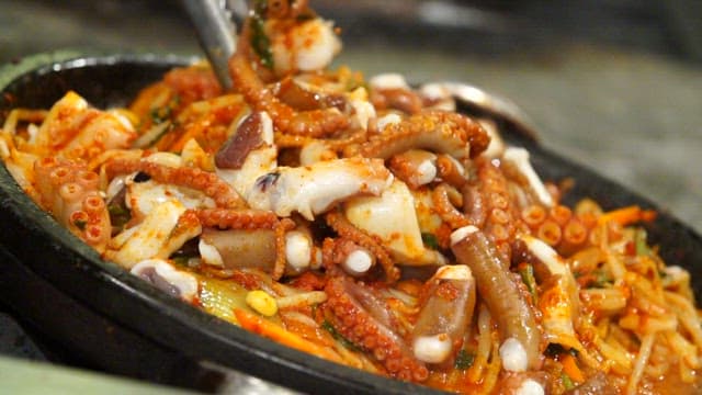 Cutting spicy seasoned braised octopus with scissors