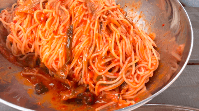 Spicy mixed noodles stirred with chopsticks