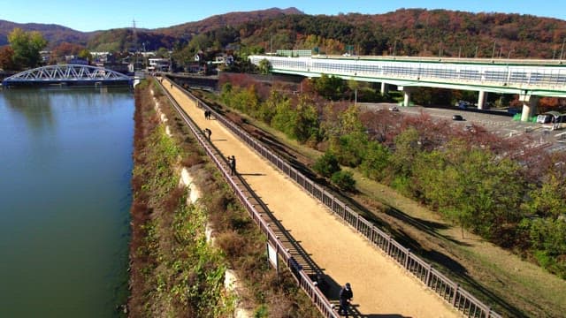 Beautiful Baegunhosu Lake with autumn trees and a view of the walking trail of people