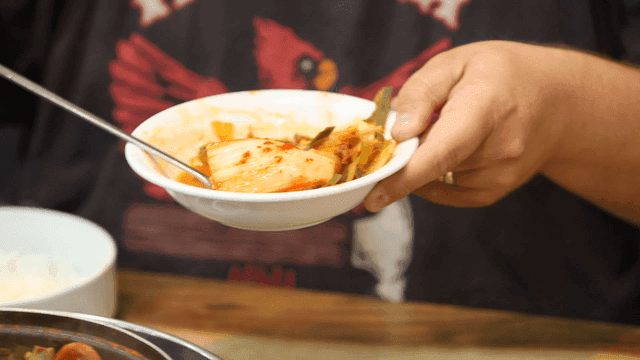 부대찌개가 담긴 그릇에 올라가는 김치