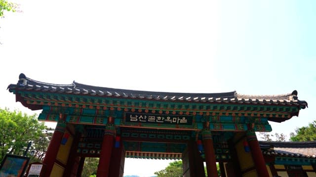 Traditional Korean gate with intricate design on a sunny day