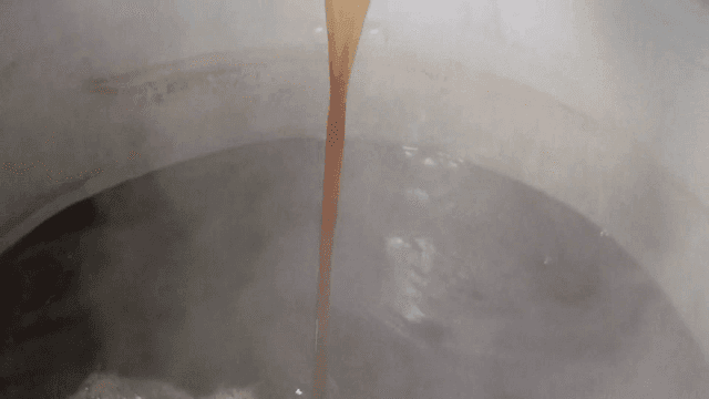 Ladle pouring broth into a pot