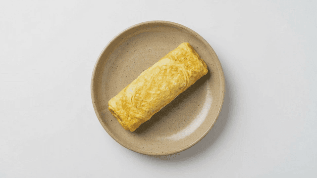 Yellow rolled omelet on plate