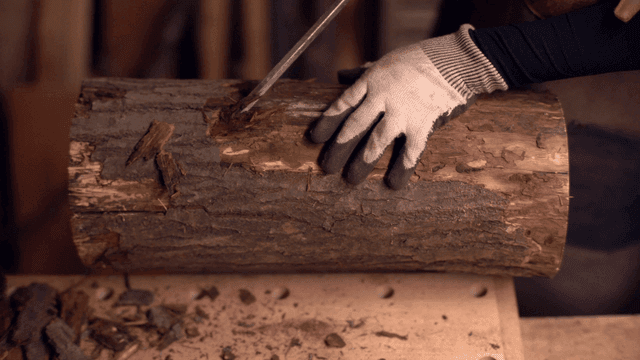 작업장에서 통나무를 조각하는 장인