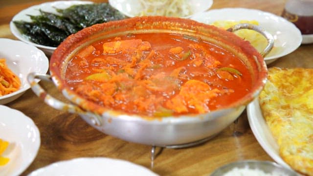 다양한 반찬과 함께 플레이팅된 매운 돼지찌개