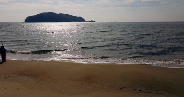 바다 너머 멀리 언덕이 보이는 해변가