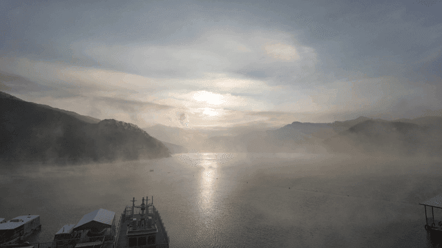 Sunrise over foggy mountains and tranquil lake