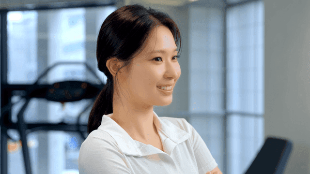 헬스장에서 미소짓는 젊은 여성의 옆모습