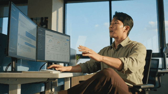 Man working at a desk with dual monitors