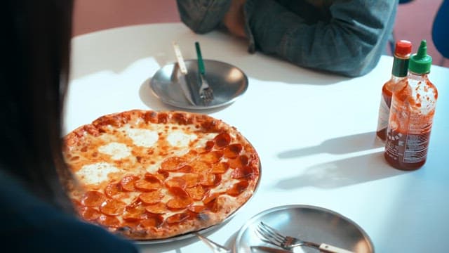 여자가 실내에서 피자 사진을 찍는 모습