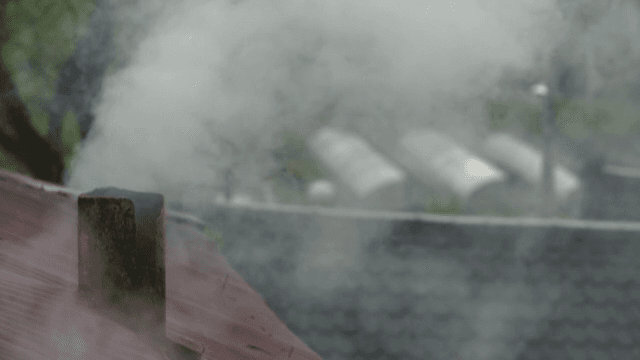 지붕 위 굴뚝에서 피어오르는 연기