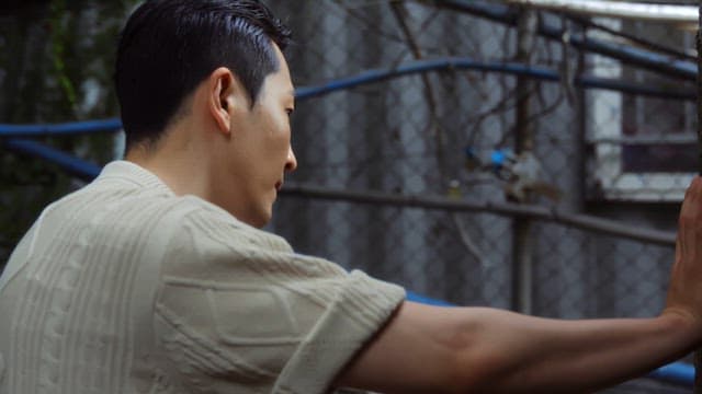 Man standing near a fence outdoors