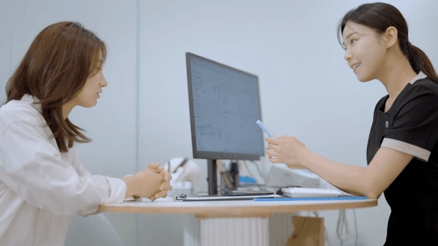 상담실에서 사진을 보여주며 상담을 받는 여성