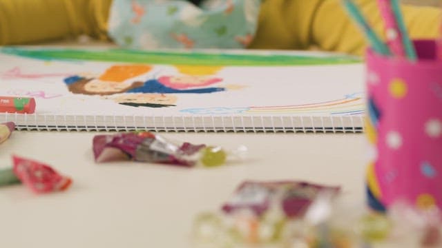 Child Putting Crayons Back in Place After Coloring