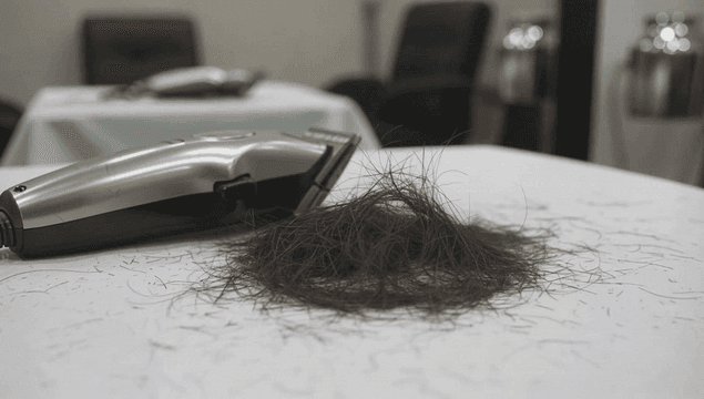 Hair clippers and cut hair on a table