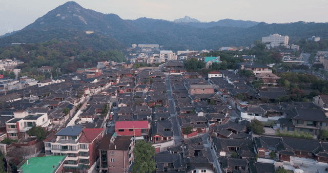 Traditional hanok village with distant mountain view
