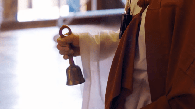 종을 흔들고 있는 승려의 손