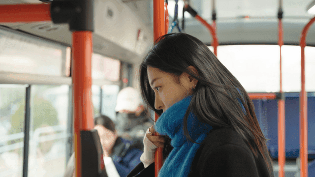 Profile of a tired woman standing on a bus