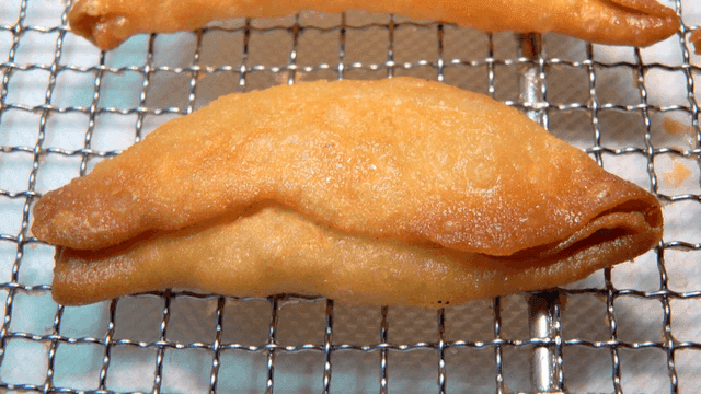 식힘망 위에 갓 튀긴 황금빛 만두들